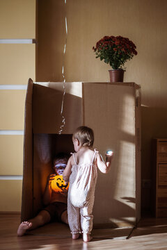 child play during Halloween celebration in cozy room