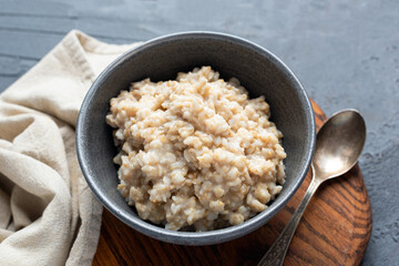 Cooked rolled oats in bowl. Vegan oatmeal porridge. Copy space