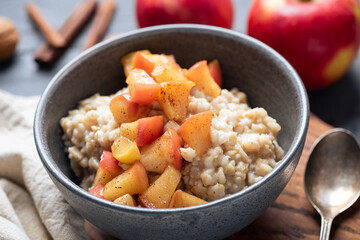 Apple pie oatmeal bowl. Healthy vegan breakfast cooked oats with sauteed apples and cinnamon