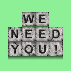 We Need You. Word on stone blocks. Isolated on a green background. Design element.Lifestyle.