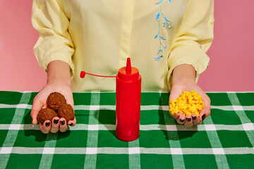Mix dish. Female hands holding meat balls canned corn isolated over pink background. Concept of food, creativity. Food pop art photography.