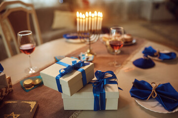 Gift boxes on festive table setting for Hanukkah.
