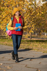 smiling teen girl back to school in autumn. full length