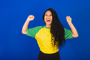 Young black Brazilian woman, soccer fan. celebrating and celebrating.