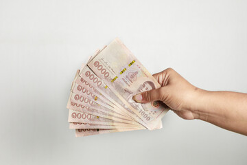 Several Thai banknotes in a woman's hand