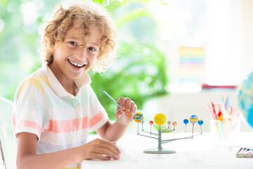Child with solar system model. Kids planetarium. © famveldman