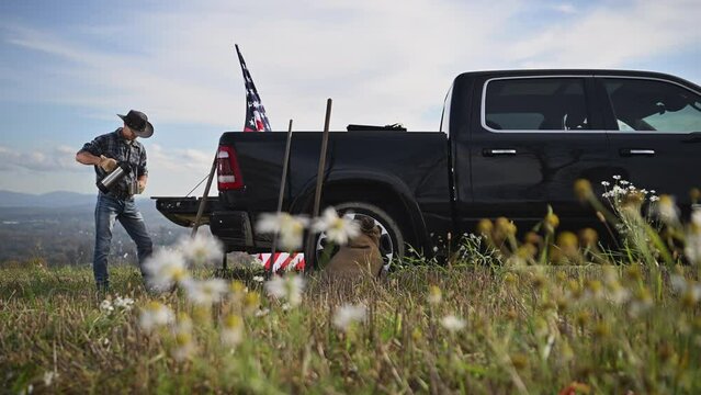 American Cowboy Staying on His Farmland and Drinking Coffee Next to His Truck