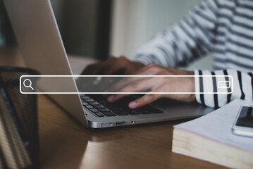 Close up image hand of young businessman using laptop with search engine icon and use the search engine menu to find information on the Internet.