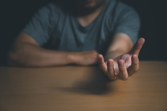 Male empty hand open a palm up on wooden desk over dark background.