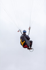 Skydiving extreme sports- parachutist with a parachute unfolded. The sportsman flying on a paraglider. Beautiful paraglider in flight on a light background.