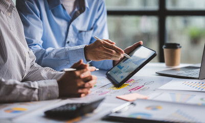 Young colleagues discussing business and price chart analyzes business people on the table great in...