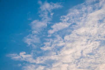 Altocumulus clouds with blue sky in the morning. Middle level layer clouds, extraordinary cloud formation, winter season is coming concept.