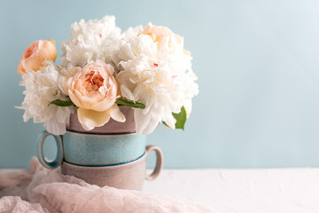 Romantic postcard with tender colorful summer roses and peonies flowers against blue background in vase. Selective focus. Place for text. Still life - 541025260