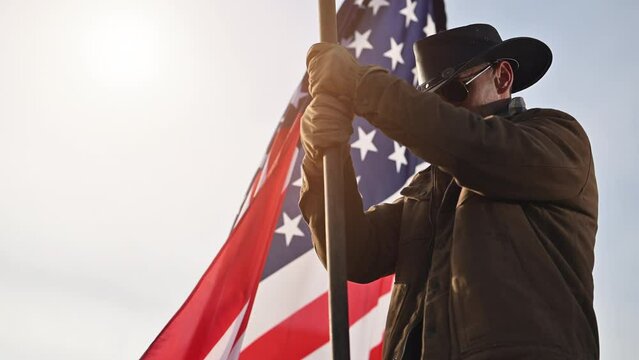 Proud Caucasian American Cowboy in His 40s Staying Next to USA National Flag. Slow Motion Footage