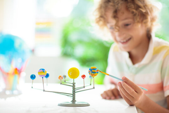 Child with solar system model. Kids planetarium.