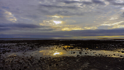 Obraz premium Dawn solitude on a Haida Gwaii, BC, beach with sunrise reflected in tide pool.