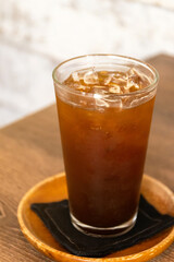Iced americano on wooden table. Cold drink made with ice, espresso, and chilled water.
