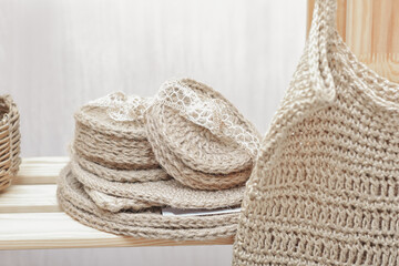 Jute knitted placemats and coasters on a store shelf, hand made kitchen accessories. Eco natural style home decor. Zero waste reusable recyclable biodegradable coaster. © Yulia Panova