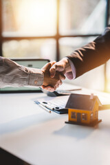 Handshake real estate agents deliver sample homes to customers. mortgage loan agreement Make a...