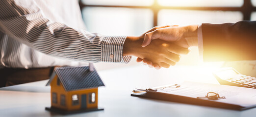 Handshake real estate agents deliver sample homes to customers. mortgage loan agreement Make a contract for hire purchase and sale of a house. and home insurance contracts home mortgage loan concept