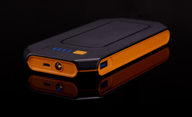 Power bank on a black surface with a black background.