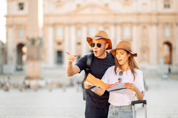 Happy tourists looking at a map. Couple of tourists on vacation in Rome, Italy. A young couple of...