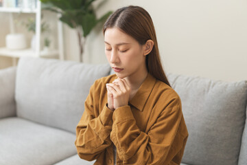 Fototapeta na wymiar Believe faith charity, calm asian young woman show gratitude, folded hands in prayer feel grateful, meditating with her eyes closed, praying to request God for help. Religious, forgiveness concept.