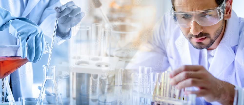Wall mural attractive scientist man testing chemical sample in flask at laboratory with lab glassware backgroun