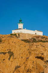 The old lighthouse on the rocky Pietra peninsula in the L'Ile-Rousse commune of France on Corsica,...