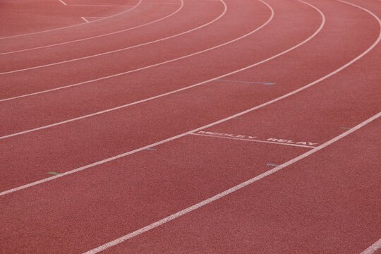 White lines forming lanes of an athletics track made of red rubber