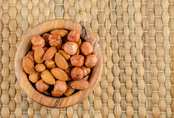 Nuts in assortment on a straw mat with a place to copy.