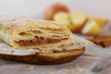 apple pastry strudel roll with cinnamon on grey marble table