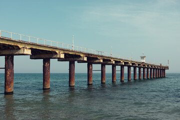 Fototapeta na wymiar Old and rusty pier in the sea.