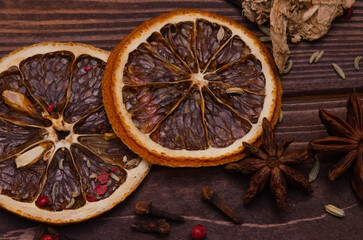Spices for the preparation of fragrant mulled wine scattered on a wooden table.