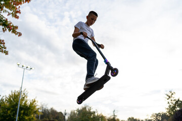 boy jumping with his scooter