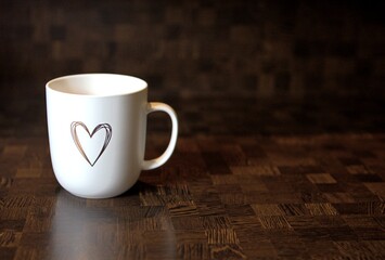 white ceramic cup with a heart on a wooden table