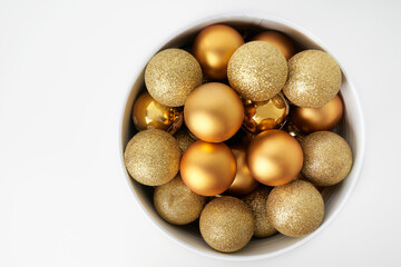 a cone full of golden Christmas balls with white background and space for copying
