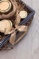 Panier cadeau rempli de bocaux et conserves gastronomiques avec ruban doré