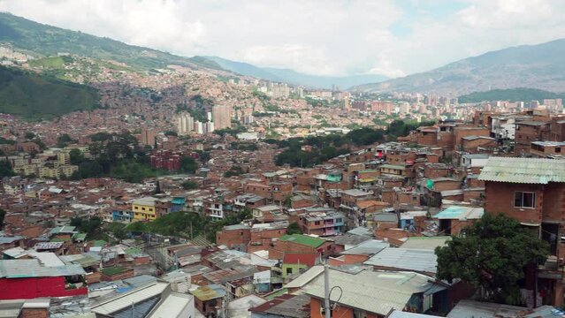 Panning shot of Comuna 13 slum in Medellin, Colombia. Once one of the most dangerous neighbourhoods in the country, the Comuna 13 reinvented itself in recent times and is now considered safe to visit.