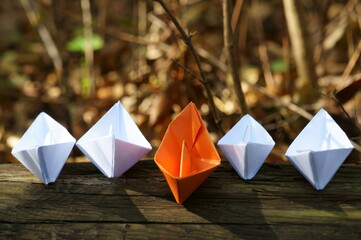 A group of paper boats on a colored background.