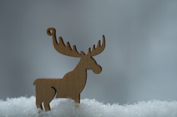 Christmas toy wooden deer on the background of a wet window.