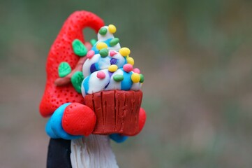 A figure of a dwarf with a cupcake in his hand.