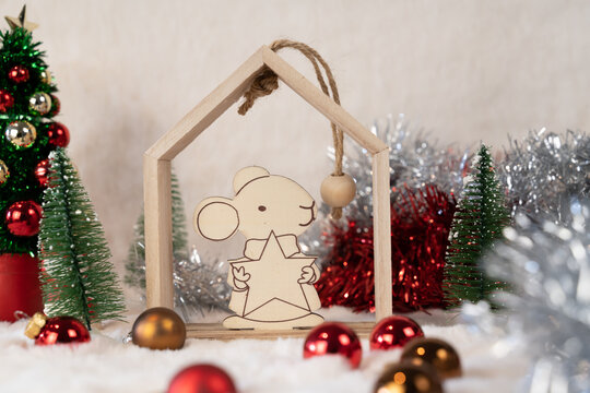 Petite souris de noël tenant une étoile en bois blanc dans un décor de Noël