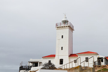 Fototapeta na wymiar White Lighthouse Building At Cape St. Blaize With Overcast Sky, Mossel Bay, South Africa
