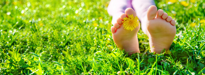 Child feet on the grass. Selective focus.