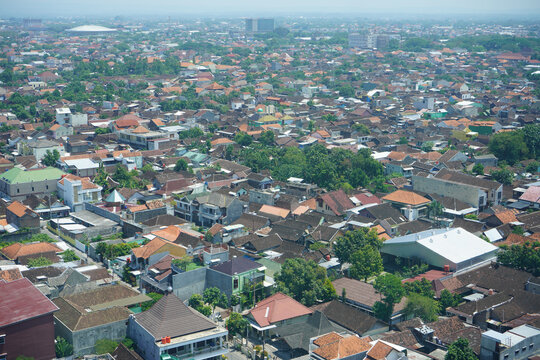 Surakarta, Indonesia - September, 2022 : A view of the densely populated residential area of ​​Solo City from the top of a skyscraper. There are many roof tiles of the house that look close together.