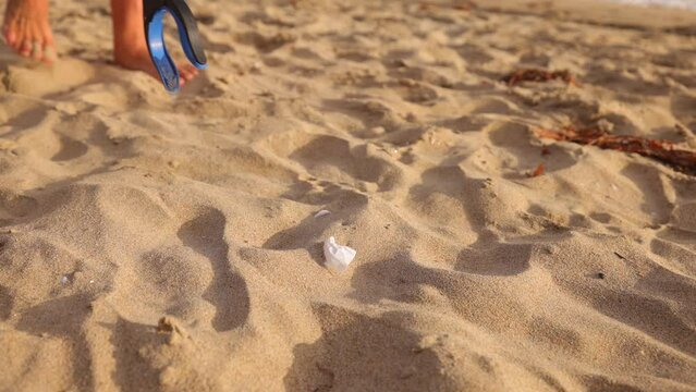 Mature 66 year old man picking up trash from a beach in Southern California