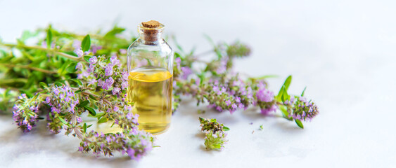 Essential oil of thyme in a bottle. Selective focus. - obrazy, fototapety, plakaty