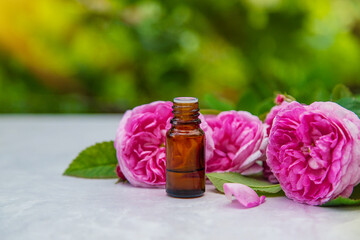 Rose essential oil in a bottle. Selective focus.