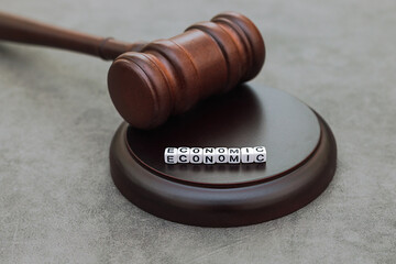 Economy Concept. Law theme. Judge gavel handcuffs and text word economic on grey table. Mallet of...